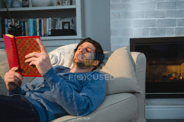 focused_208543932-stock-photo-man-reading-book-while-lying.jpg